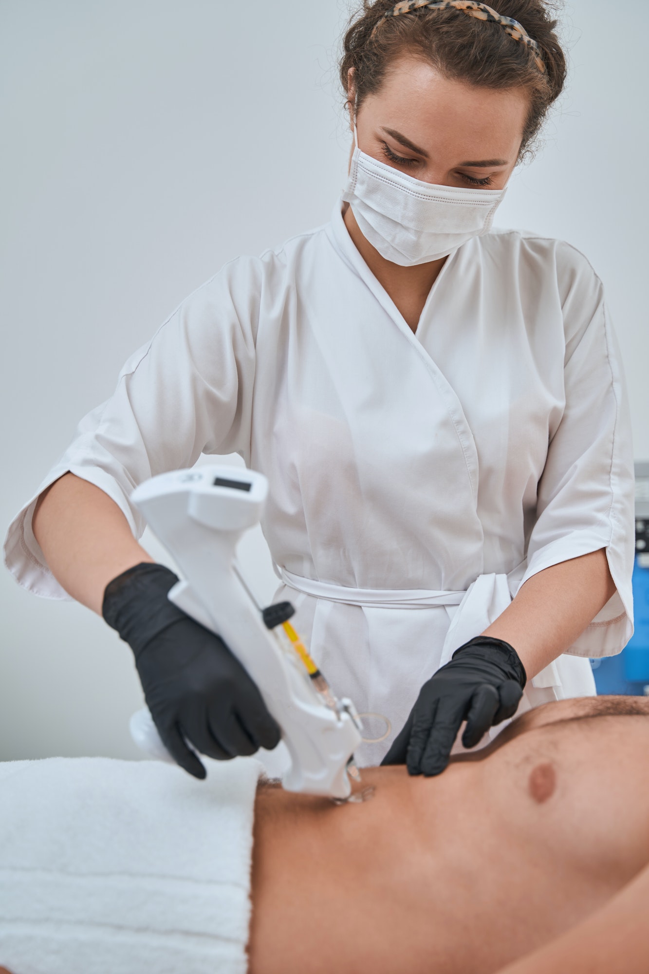 Female doctor using a mesogun for an aesthetic procedur